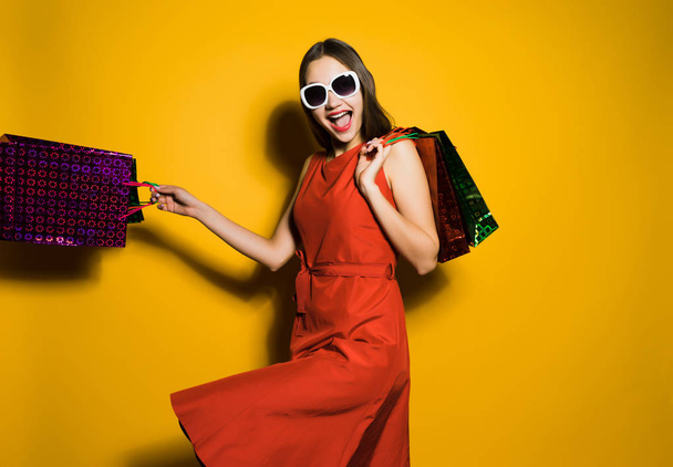happy woman holding packages with purchases in hands - Foto, Imagem