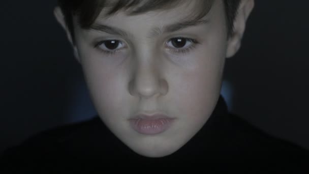 Gros plan visage de jeune garçon joue à un jeu vidéo avec ordinateur portable dans la chambre noire. Double exposition du jeu sur le visage et sur le mur
. - Séquence, vidéo