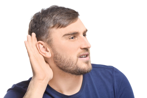 Young man with hearing problem on white background - Zdjęcie, obraz