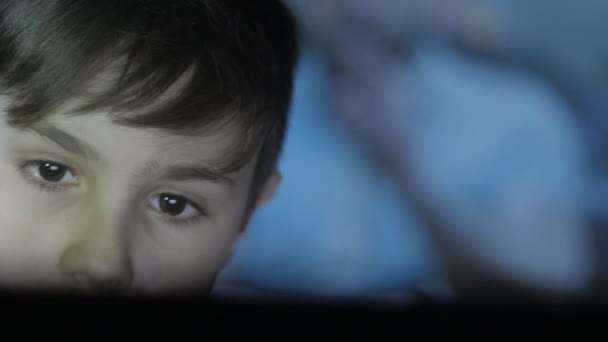 Close-up van Kid afspelen van een video-game op de console. De projectie van het spel op het gezicht en op de muur. Dubbele blootstelling. - Video