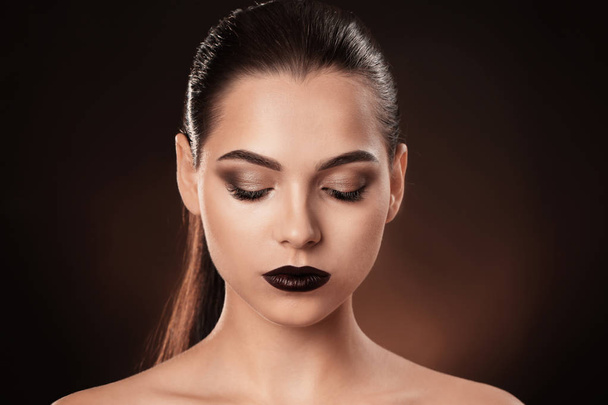 Woman with beautiful makeup on dark background. Professional visage artist work - Photo, Image