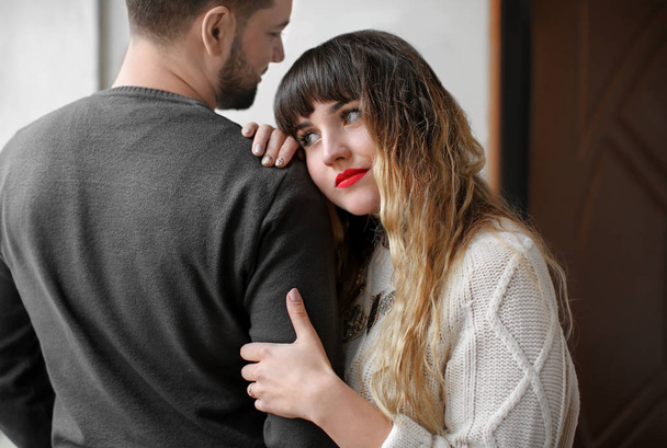 Young woman hugging her boyfriend indoors - Фото, изображение
