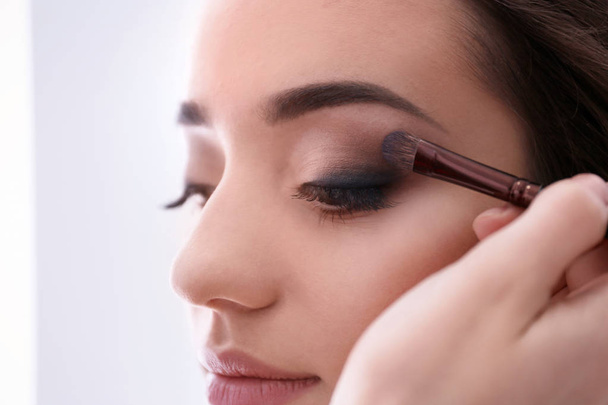 Professional makeup artist working with woman, indoors - Photo, Image