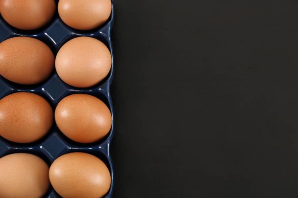 Holder with chicken eggs on table - Foto, Imagen
