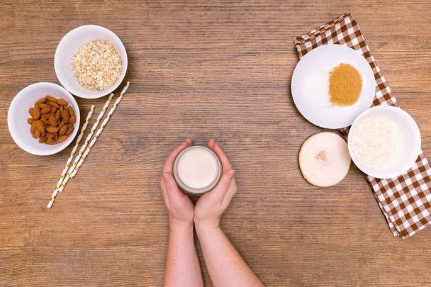 Plant alternative milk recipe: almond, oat, rice in woman hands - Foto, Imagem