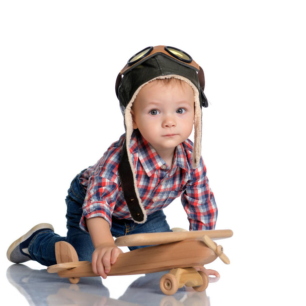 Jongetje met een houten vliegtuig. - Foto, afbeelding