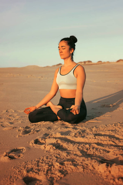 sportliche junge Frau praktiziert Yoga am Strand, Konzept des gesunden Lebens und des natürlichen Gleichgewichts zwischen körperlicher und geistiger Entwicklung - Foto, Bild