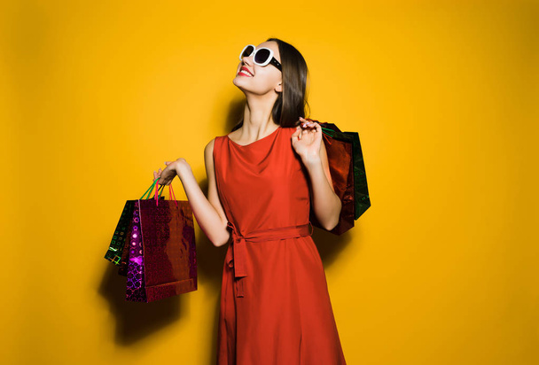 happy woman in a beautiful dress keeps shopping bags - Zdjęcie, obraz