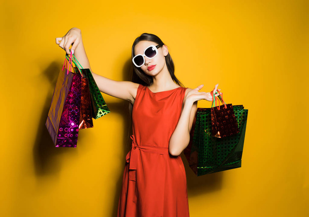 woman in a beautiful dress demonstrates shopping bags - Фото, зображення