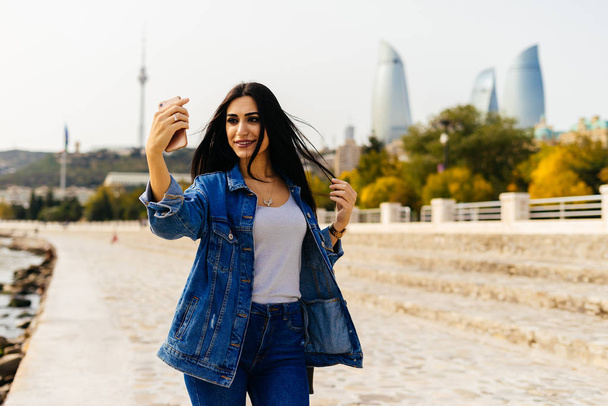 happy fashionable woman doing selfie on city background - Фото, изображение