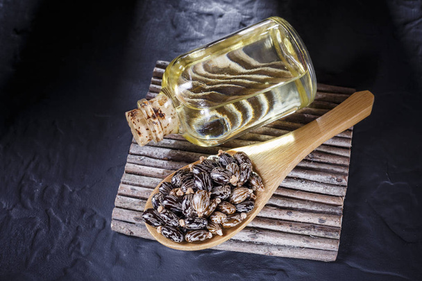 豆と黒いテーブルの上のヒマシ油 - 写真・画像