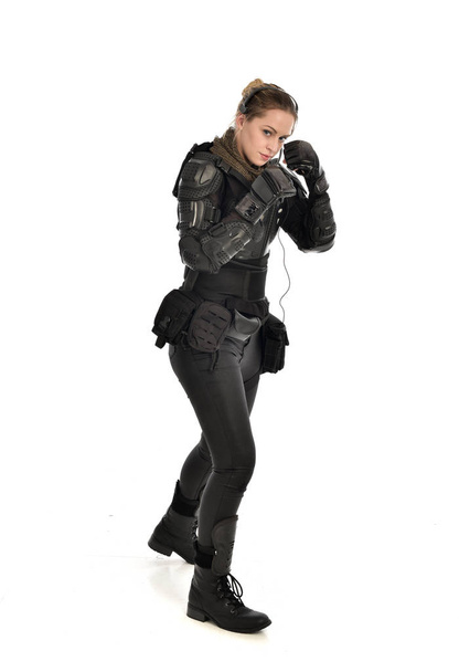 portrait complet de femme soldat portant une armure tactique noire, isolée sur fond de studio blanc
. - Photo, image