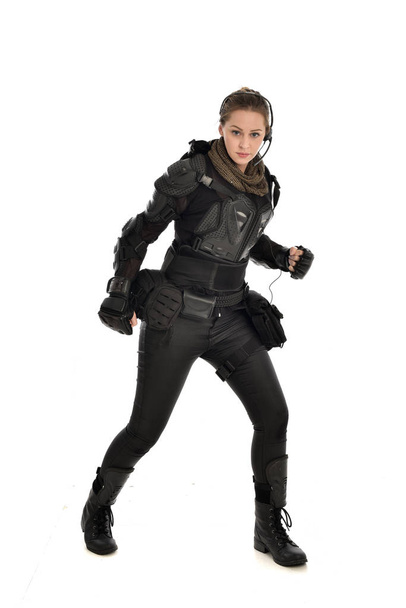 retrato de cuerpo entero de soldado femenino con armadura táctica negra, aislado sobre fondo blanco del estudio
. - Foto, imagen