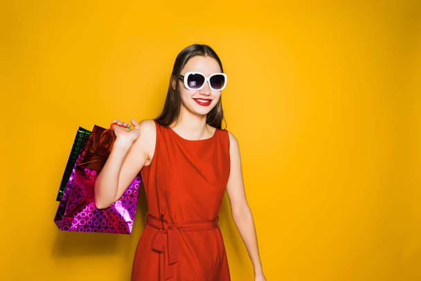 woman on a yellow background holds her shopping in her hands - Photo, image