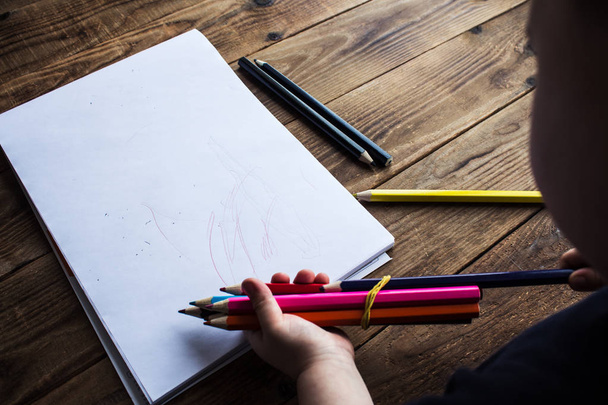 маленький мальчик держит цветные карандаши
 - Фото, изображение