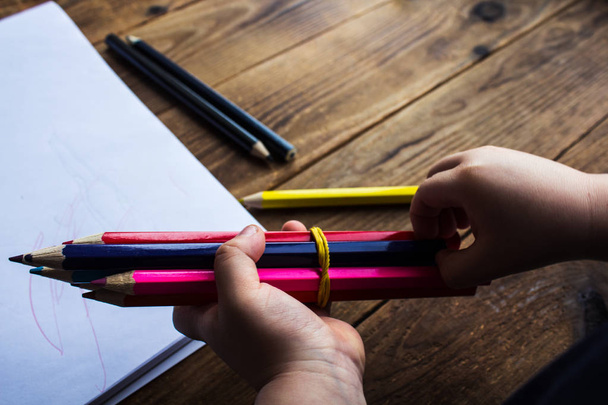 niño sostiene lápices de colores
 - Foto, Imagen