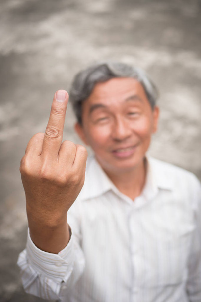Senior oude man flipping middelvinger, onbeleefd hand teken gebaar - Foto, afbeelding