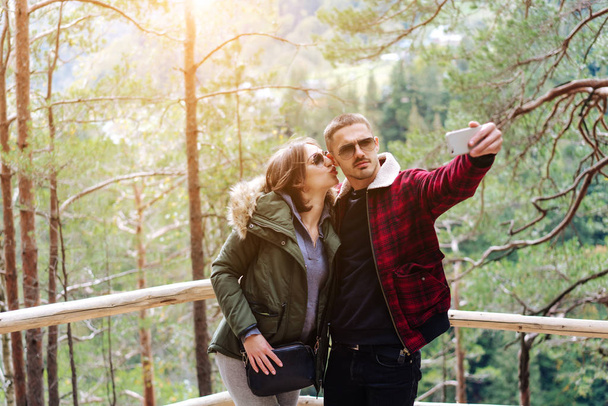 чоловік і жінка в лісі беруть селфі
 - Фото, зображення
