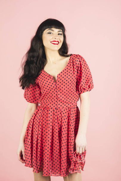 Girl with brunette hair in red dress with polka dot. - Foto, afbeelding