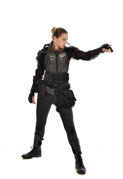 retrato de cuerpo entero de soldado femenino con armadura táctica negra, aislado sobre fondo blanco del estudio
. - Foto, Imagen