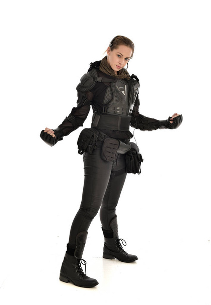 portrait complet de femme soldat portant une armure tactique noire, isolée sur fond de studio blanc
. - Photo, image