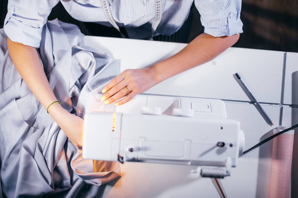 top view cropped photo of white working sewing machine with tailors arms - Фото, зображення