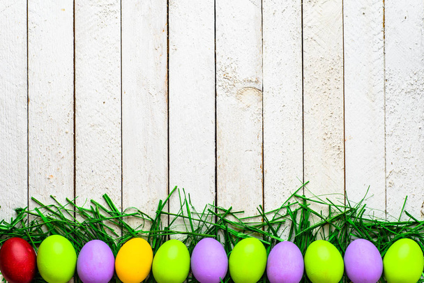 Happy easter eggs on wooden background, colorful eggs on white boards - Photo, image