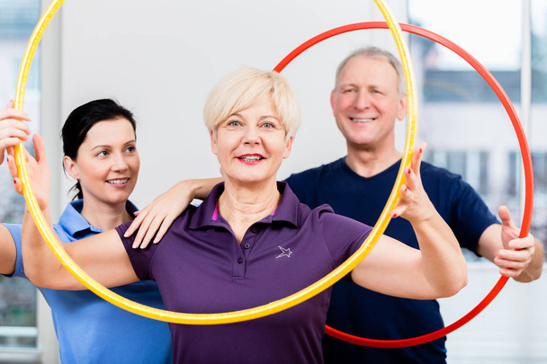 Pareja mayor en fisioterapia haciendo ejercicio con hula hoop
 - Foto, imagen