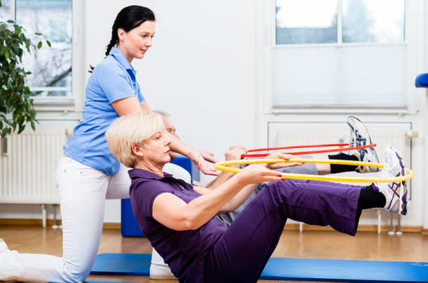 Seniorpaar in der Physiotherapie macht Übung mit Hula Hoop - Foto, Bild