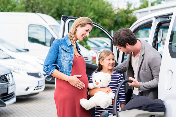 Сім'я купує машину, матір, батька та дитину в дилерському центрі
 - Фото, зображення