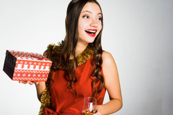 woman on a yellow white background holds a New Year gift - Foto, Imagem