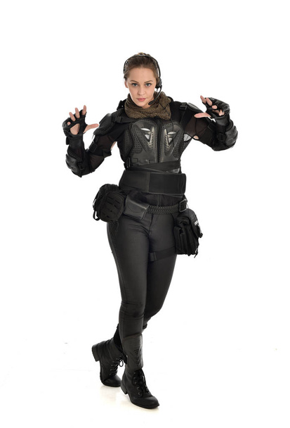 ritratto a figura intera di soldato donna con armatura tattica nera, isolata su sfondo bianco
. - Foto, immagini