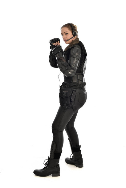retrato de cuerpo entero de soldado femenino con armadura táctica negra, aislado sobre fondo blanco del estudio
. - Foto, Imagen