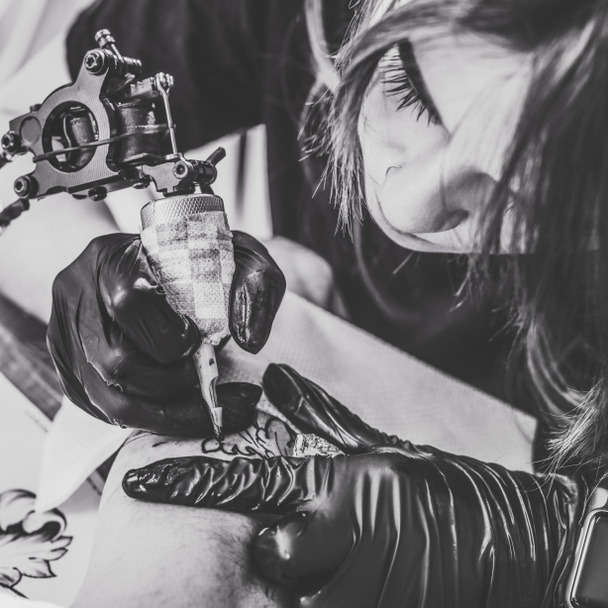 Foto en blanco y negro del tatuaje de la mujer durante el proceso de tatuaje
 - Foto, Imagen