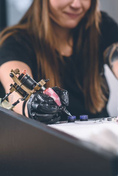 Przycięte widzenia kobiece tatuażysta praca z narzędziem atrament - Zdjęcie, obraz