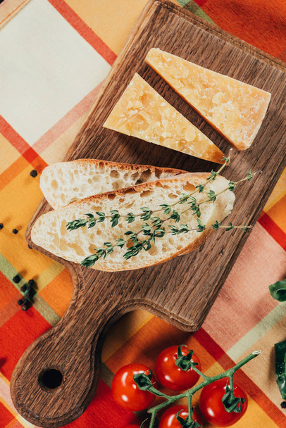 elevated view of baguette and parmesan cheese on wooden board - Photo, Image