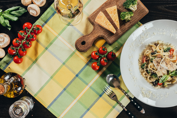 Κάτοψη των ζυμαρικών με φιλέτο πέρκας τούρνα και κρασί στο τραπέζι - Φωτογραφία, εικόνα