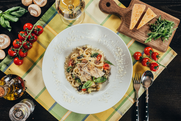 top view of pasta with pike perch fillet and grilled vegetables on plate - Zdjęcie, obraz