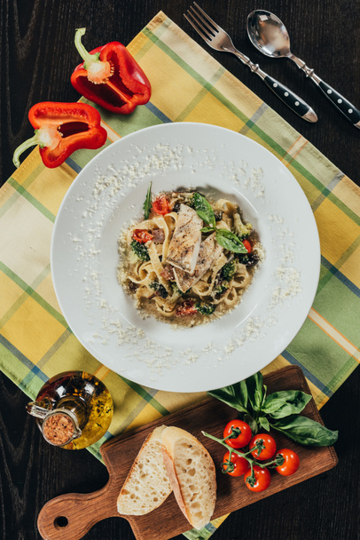 bovenaanzicht van pasta met snoeken baars kipfilet en gegrilde groenten op tafel - Foto, afbeelding