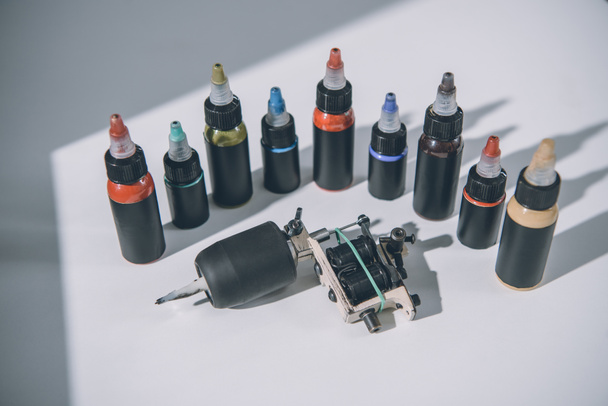 Botellas con tinta y máquina coloridas del tatuaje
 - Foto, Imagen