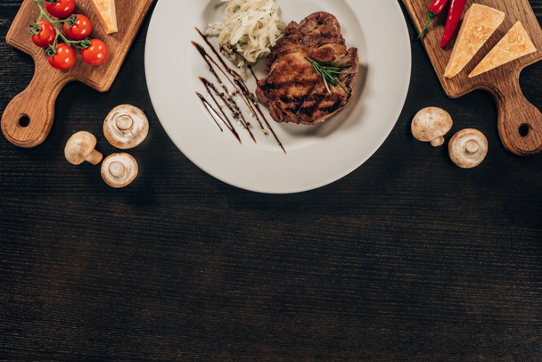 top view of beef steak and onion on dark table - Valokuva, kuva