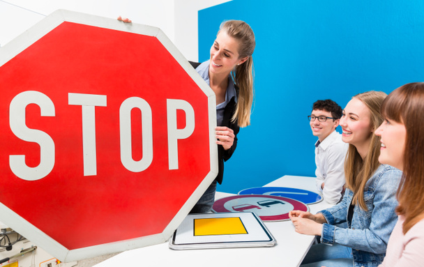 Nauczyciel wyjaśnia znaczenie znaków drogowych do klasy jazdy - Zdjęcie, obraz