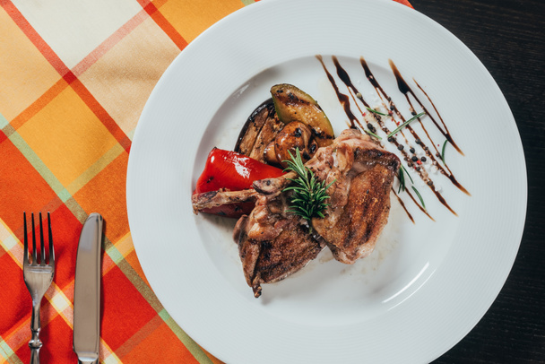top view of grilled chicken with vegetables on plate on table napkin - 写真・画像