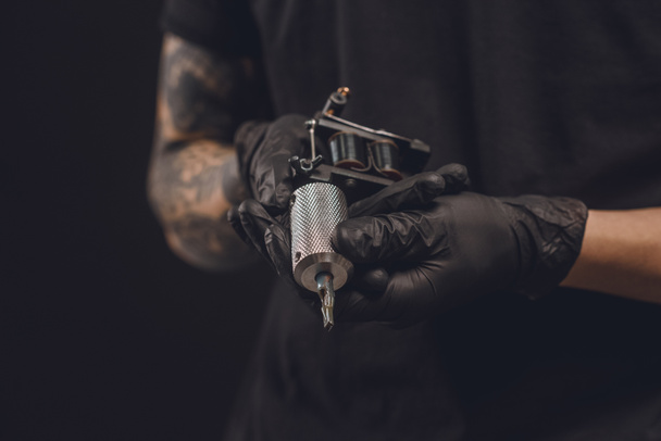 Чоловічі руки в рукавичках тримають татуювання машини ізольовані на чорному
 - Фото, зображення