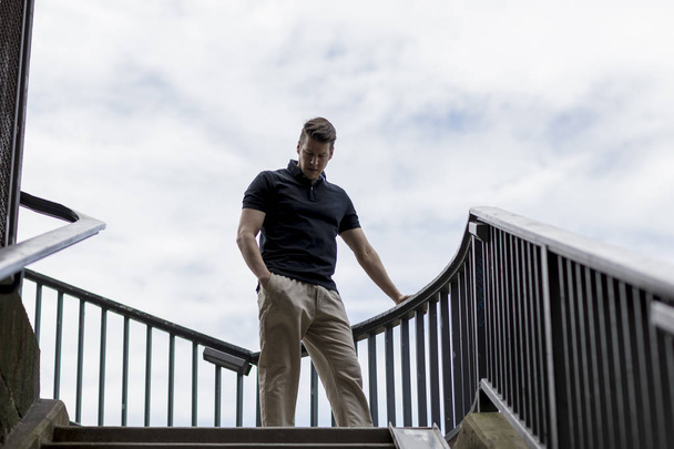 Homme debout sur une cage d'escalier extérieure
 - Photo, image