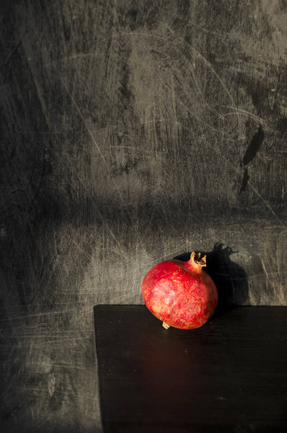 Natureza morta com romã vermelha em fundo de madeira preta
 - Foto, Imagem