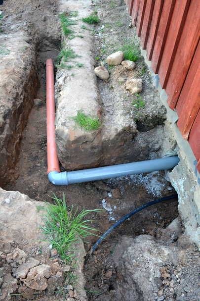 Graben in der Nähe von Haus mit Wasser- und Abwasserleitungen - Foto, Bild