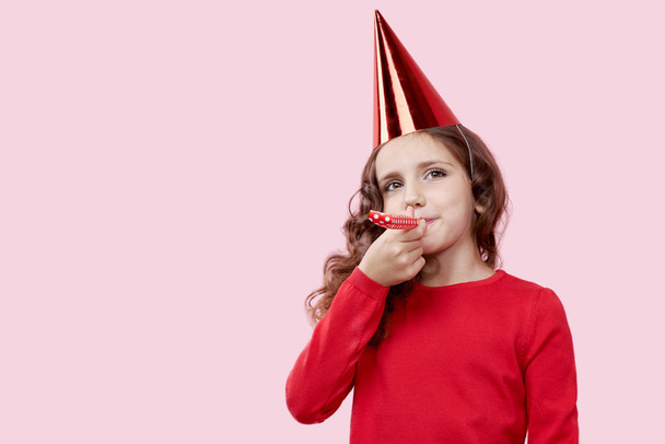 The image of a smiling girl in a red dress, celebrating the birthday of her mother.  - Foto, afbeelding