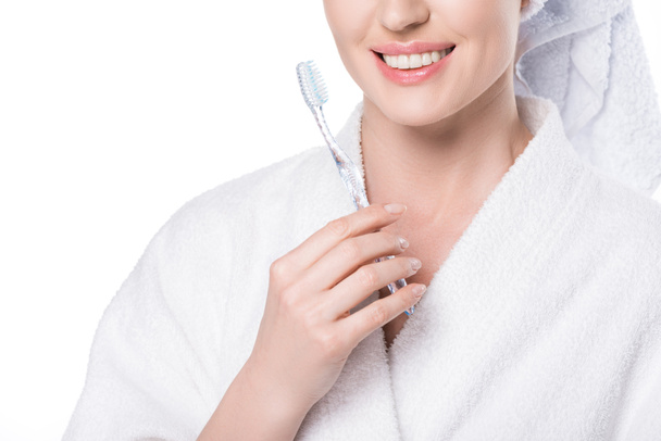 Vista recortada de hembra sonriente con cepillo de dientes en la mano aislado en blanco
 - Foto, imagen
