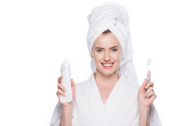 Mujer con piel limpia sosteniendo cepillo de dientes y pasta de dientes aislados en blanco
 - Foto, Imagen